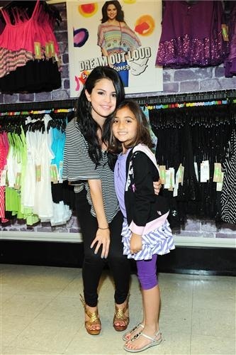 A picture of Selena wearing her clothes and posing with a fan.