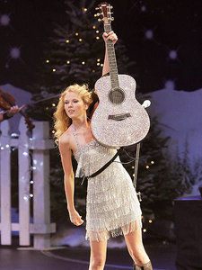 Taylor holding up her guitar!:}
