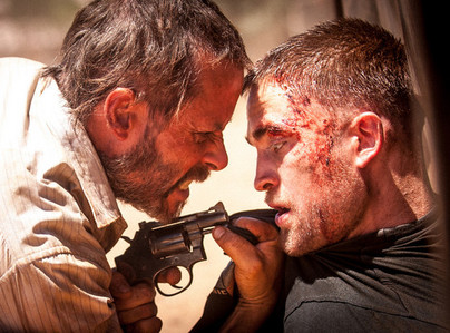  my poor(but still sexy) baby,Robert,with a gun pointed in his face from his movie The Rover,that he's currently filming<3