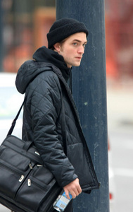 my gorgeous Robert standing next to a pole<3