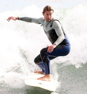  Simon Baker surfing with his hands in the air <3
