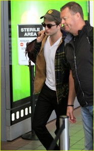  my handsome baby at the airport with a sign behind him<3