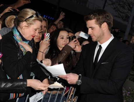  Liam giving his autograph to some lucky girls