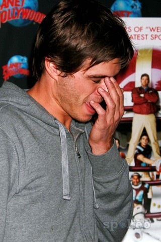  Matthew with his hand on his face, looking bashful <3333