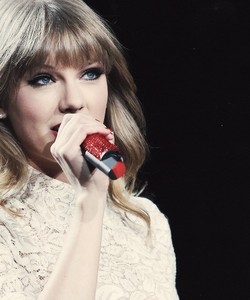 Taylor holding a microphone.:}