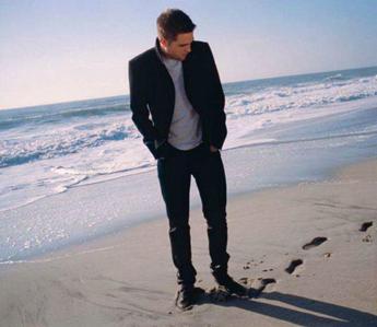  Robert on the plage with water behind him<3