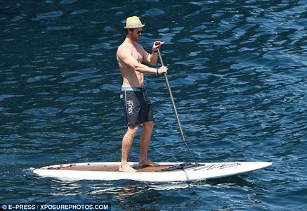  Chris standing atop a paddleboard<3