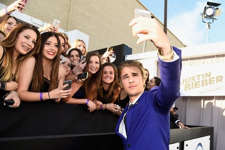 Justin taking a selfie with some lucky fans