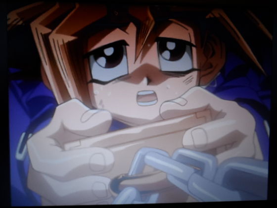 Yugi sticking by the Millennium Puzzle even though there is fire all around him!