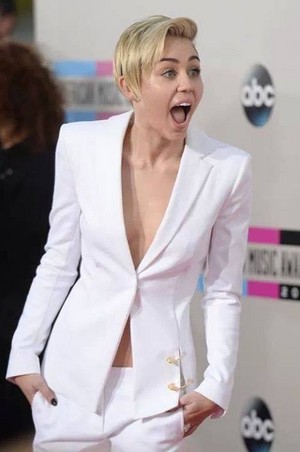 Miley in white coat nd pants with gold accessories 