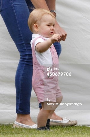  Prince George of Cambridge plays with a football whilst holding his mother Catherine