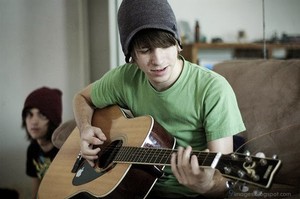 Adorable cute boy playing guitar hood
