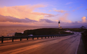  A road and lighthouse along the Oregon Coast at sunset