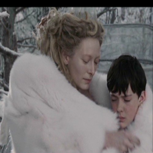 Jadis wraps her fur around Edmund.