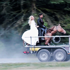 Jennifer and Colin riding the fake horse on set