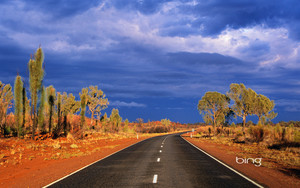  Dark storm clouds gather over Australia s Lasseter Highway as it winds through the red sand desert