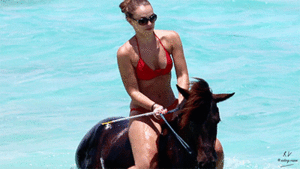 She rides on the wet stallion's back